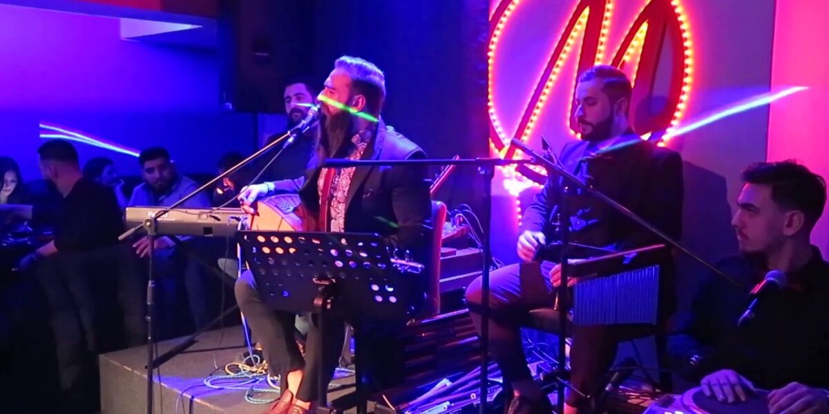 Bursa türkü barında rakı masası ve sahnede saz çalan sanatçı